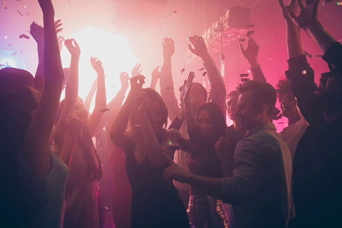 cheerfull crowd dancing around in a bar colombo